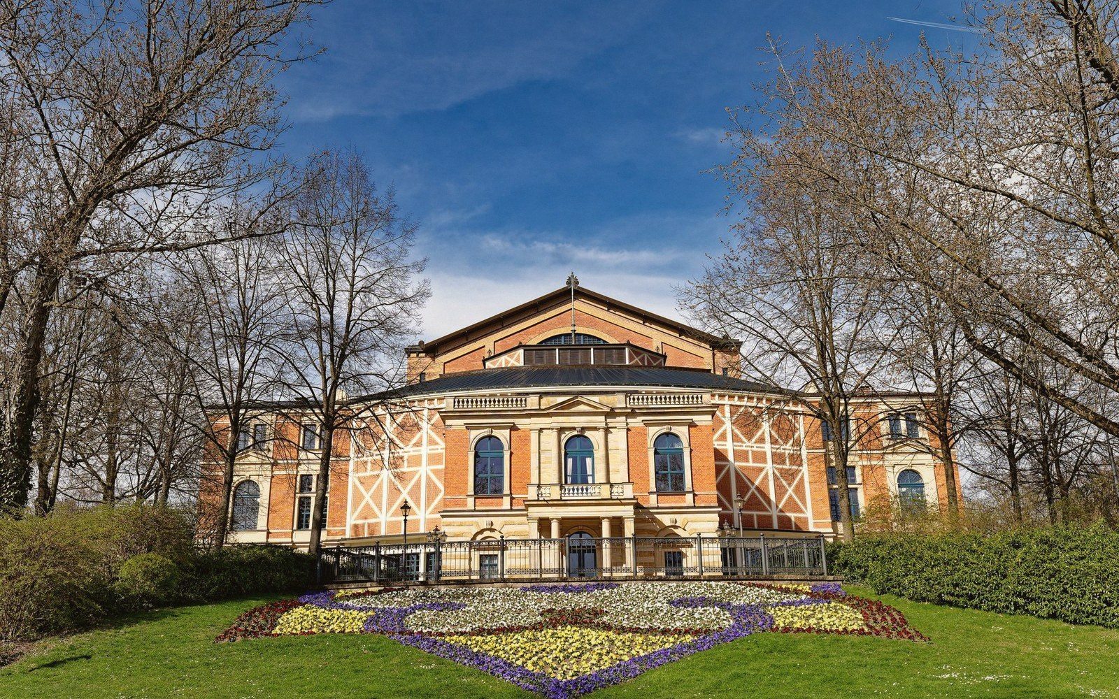Bayreuth Festival Theatre facade seen across a flower bed and lawn